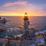 Rising sun rays through the lighthouse