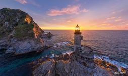 Rising sun rays through the lighthouse