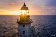 Rising sun rays through the lighthouse