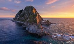 Rising sun rays through the lighthouse